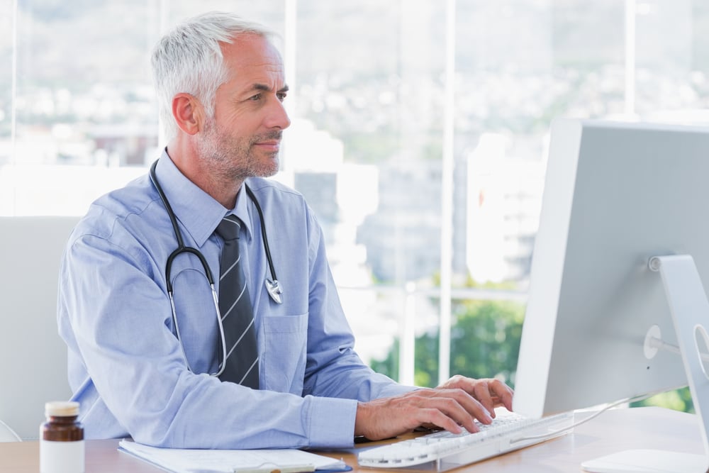 Doctor typing on his computer in the office Doctor typing on his computer in the office