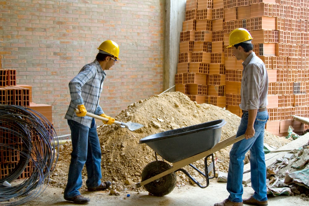 Happy construction workers wearing helmets and working - teamwork concepts